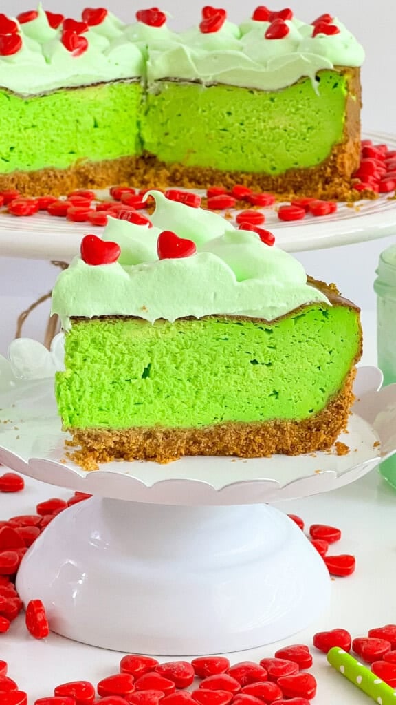 Green Grinch Cheesecake with a slice out of it.