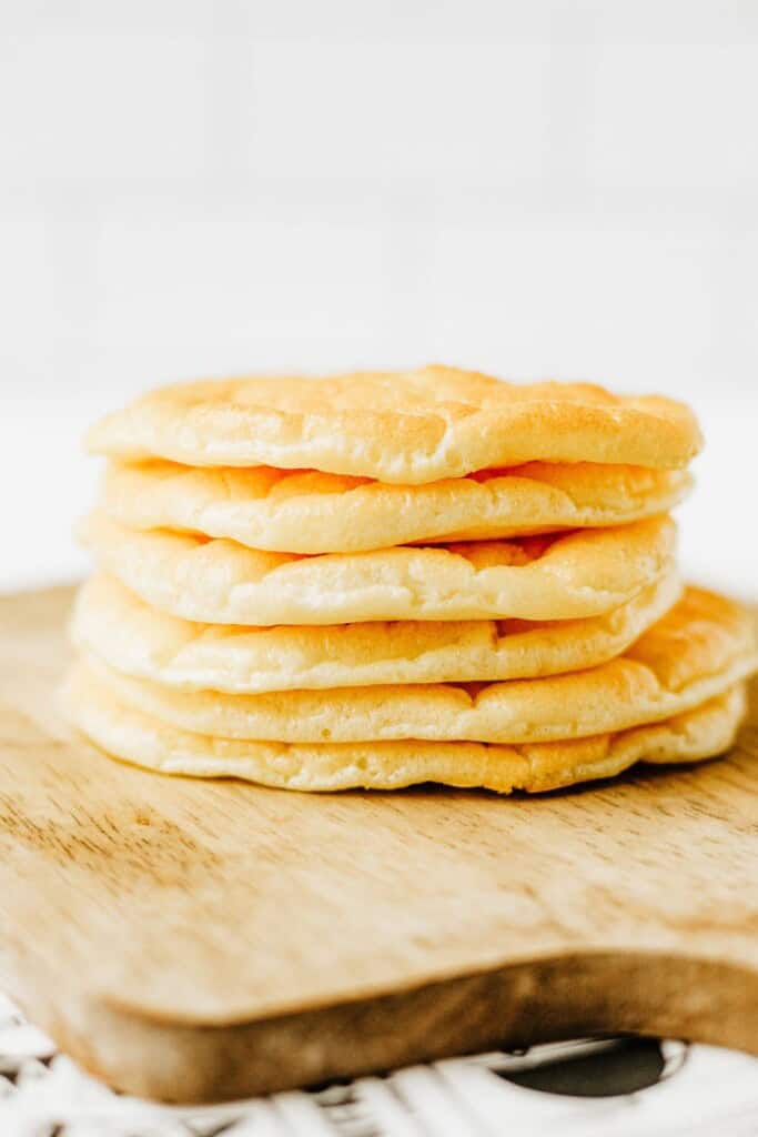 Stack of freshly baked cottage cheese cloud bread on a wooden cutting board