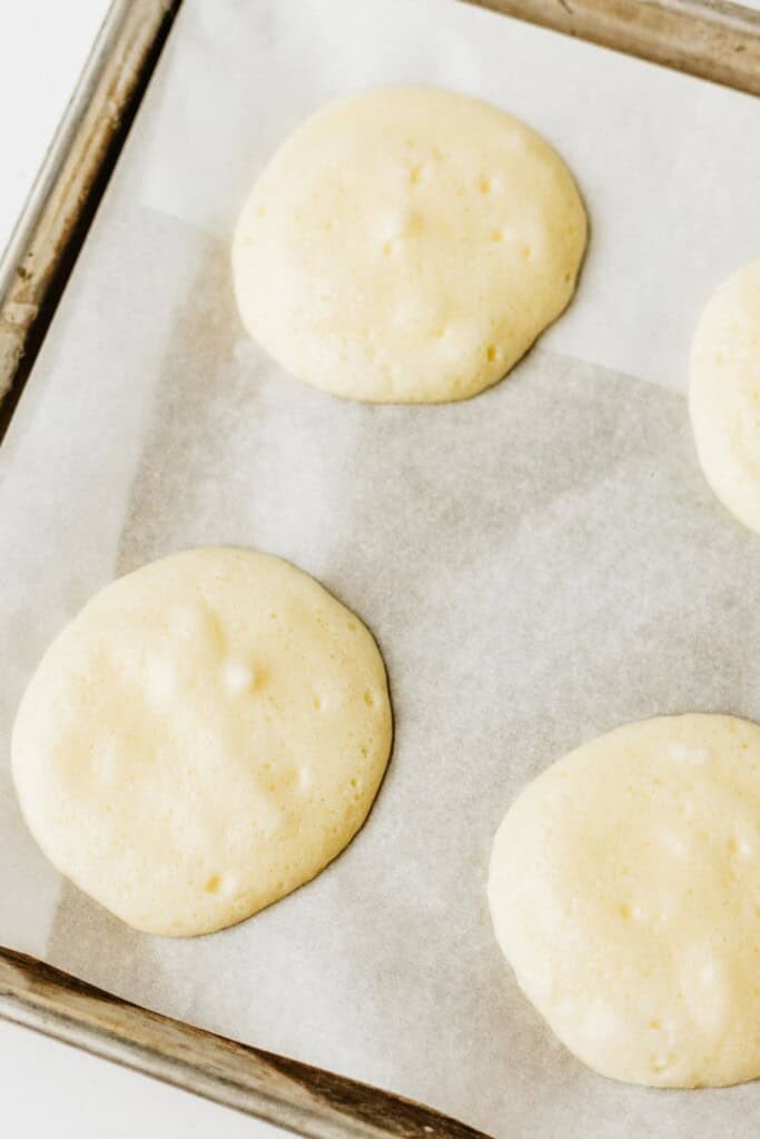 Cottage cheese cloud bread batter portioned into rounds on a parchment-lined baking sheet ready for the oven