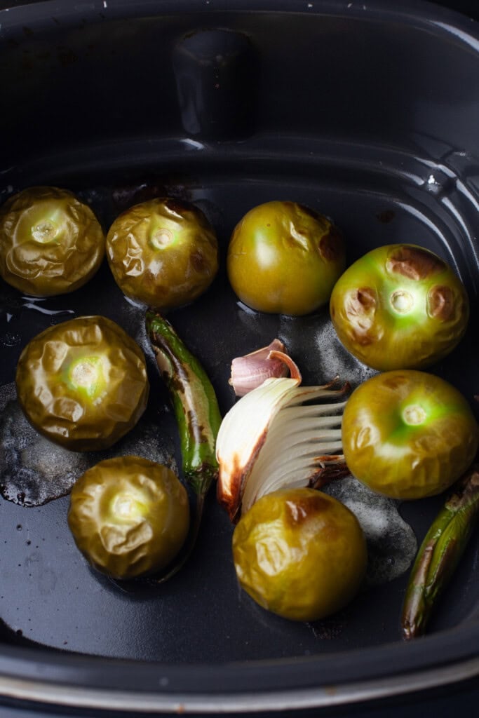 roasted green tomatoes in an air fryer basket.