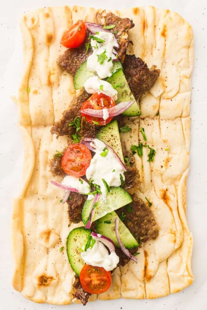 doner lamber meat and vegetables on a wrap.