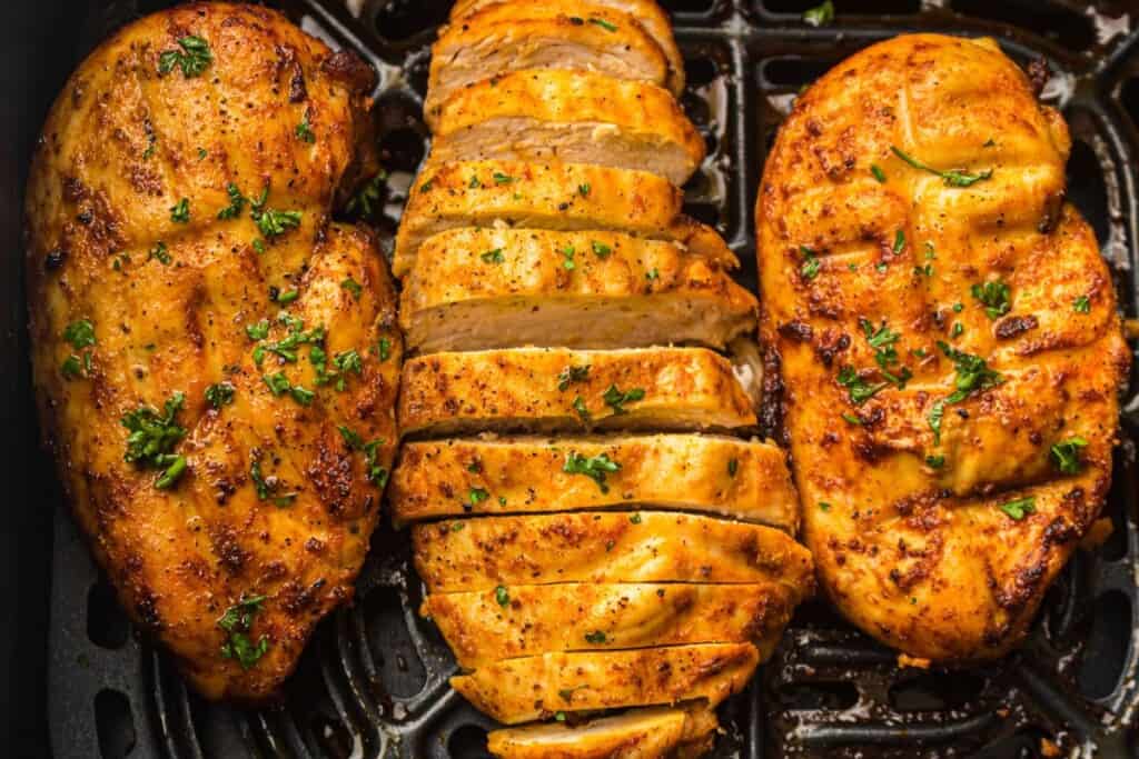 overhead view of air fryer chicken breast in air fryer basket
