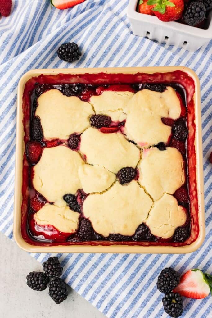 Baked vegan gluten free berry cobbler with golden biscuit topping and bubbling berry filling