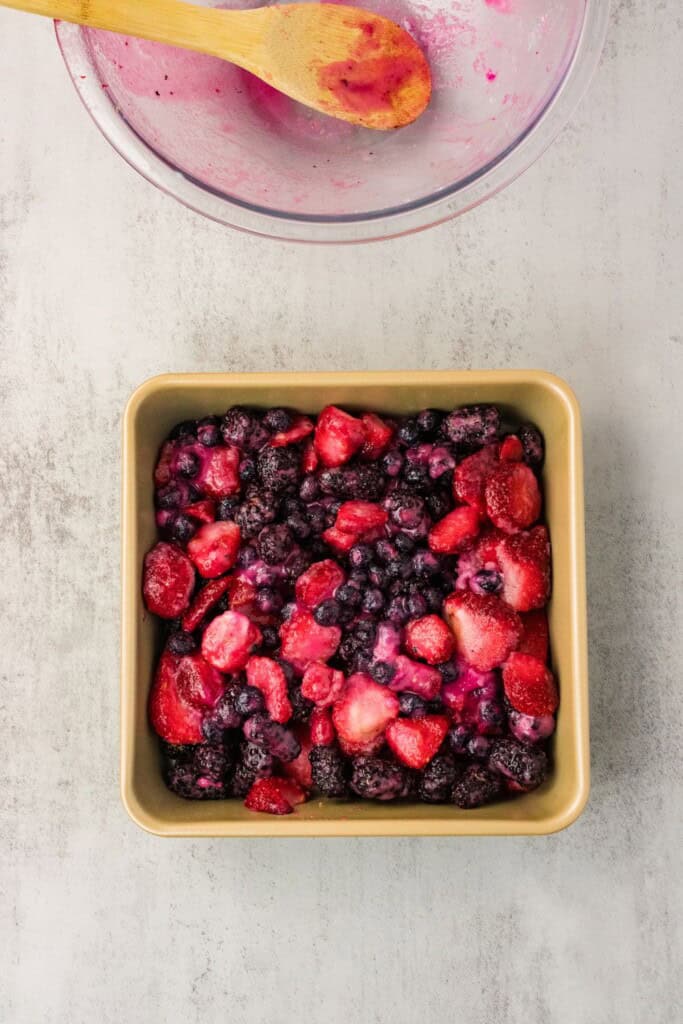 Berry filling spread in a square baking dish ready for the topping