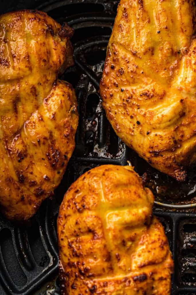 Overhead view of air fryer chicken breasts.