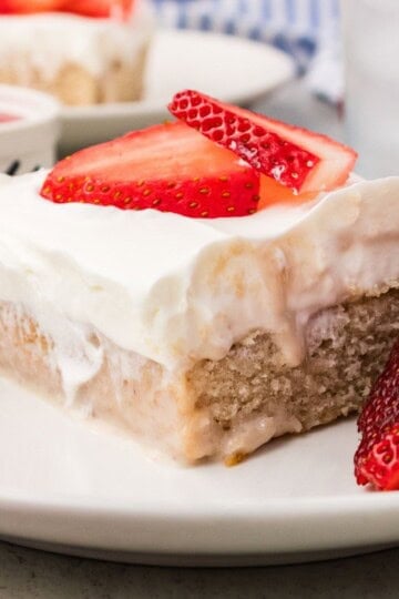 Fresh strawberry cake slice with whipped coconut cream and strawberries