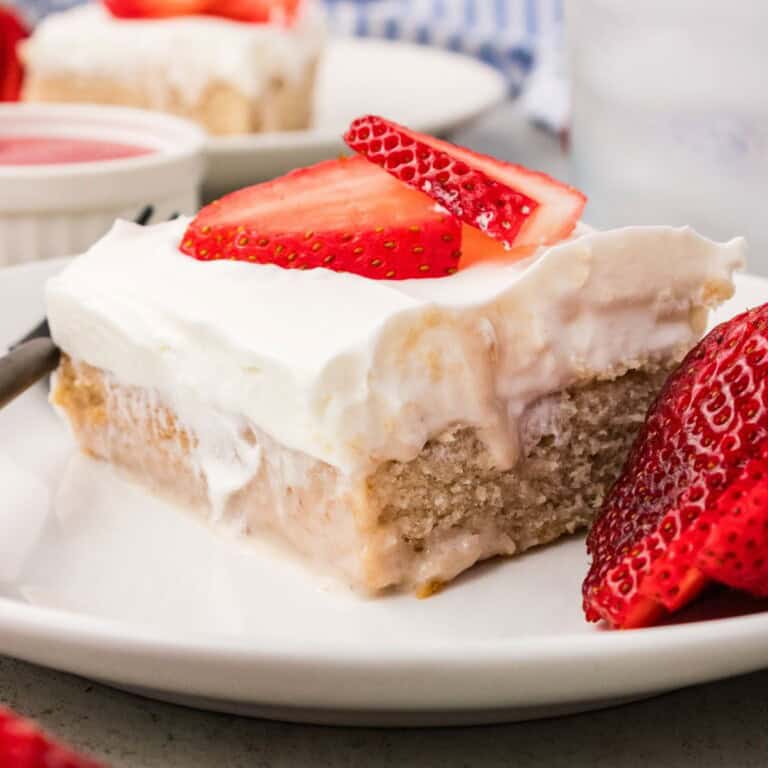 Fresh strawberry cake slice with whipped coconut cream and strawberries