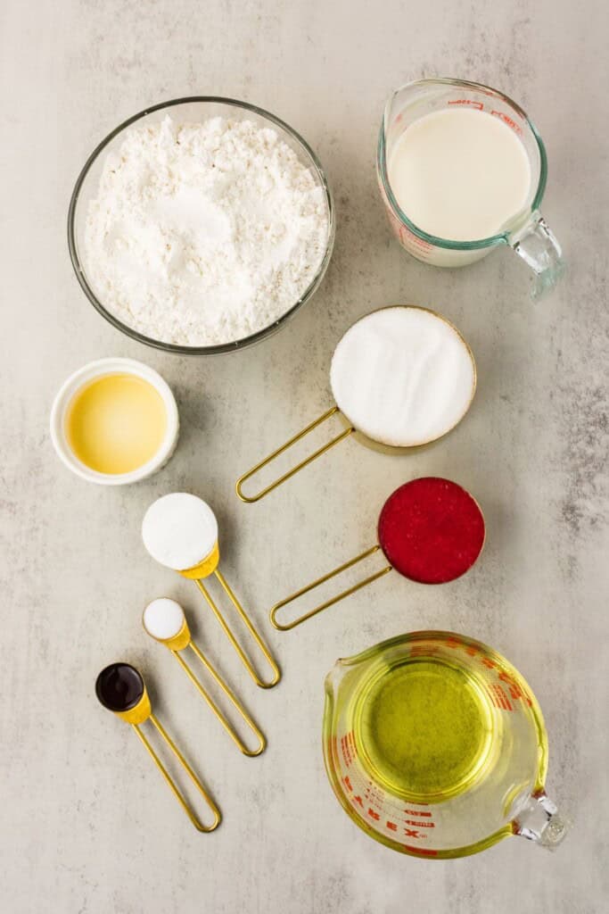 Fresh strawberry cake ingredients including gluten-free flour, sugar, dairy-free milk, strawberry purée, and oil