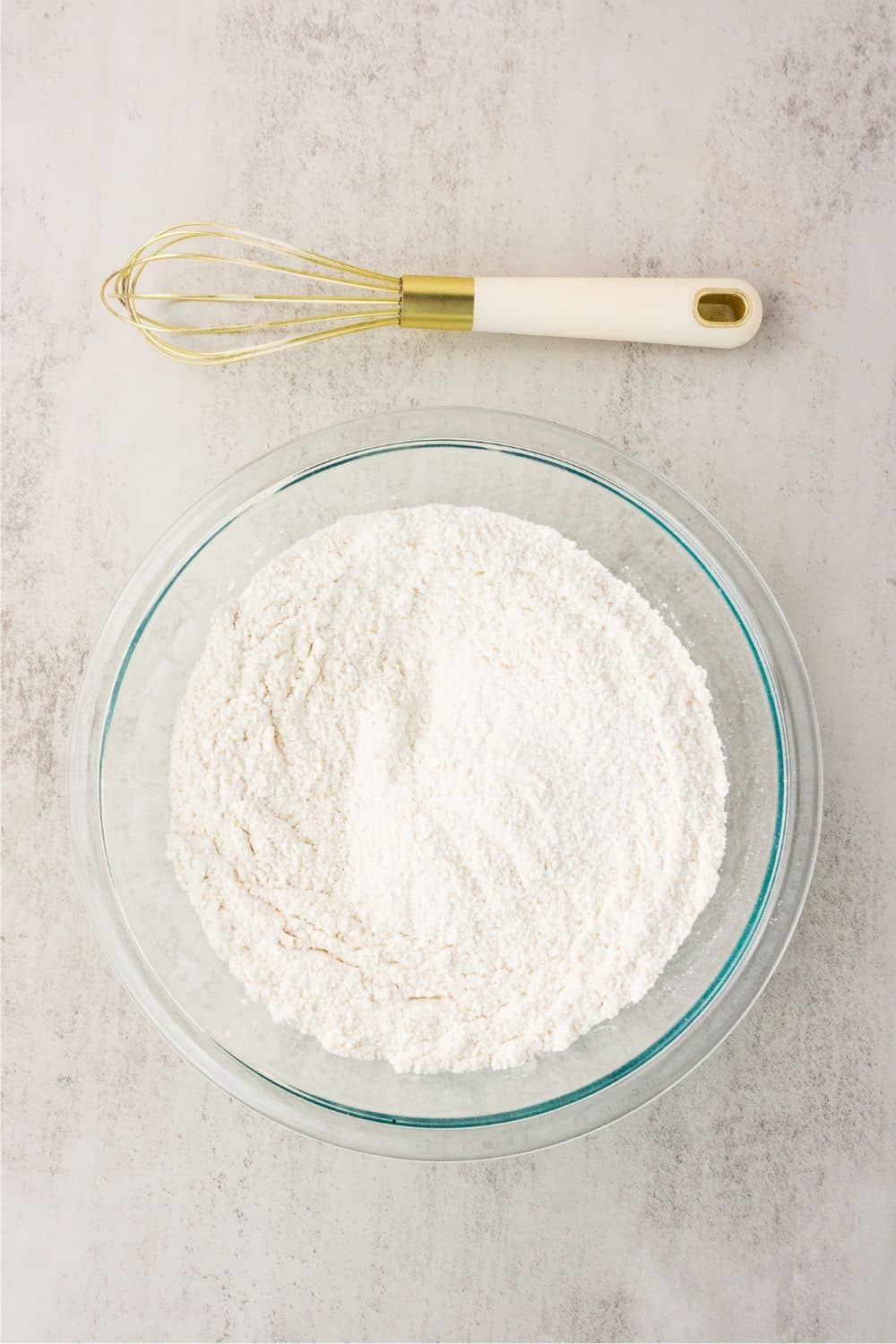 Gluten-free flour and dry ingredients whisked together in a glass bowl