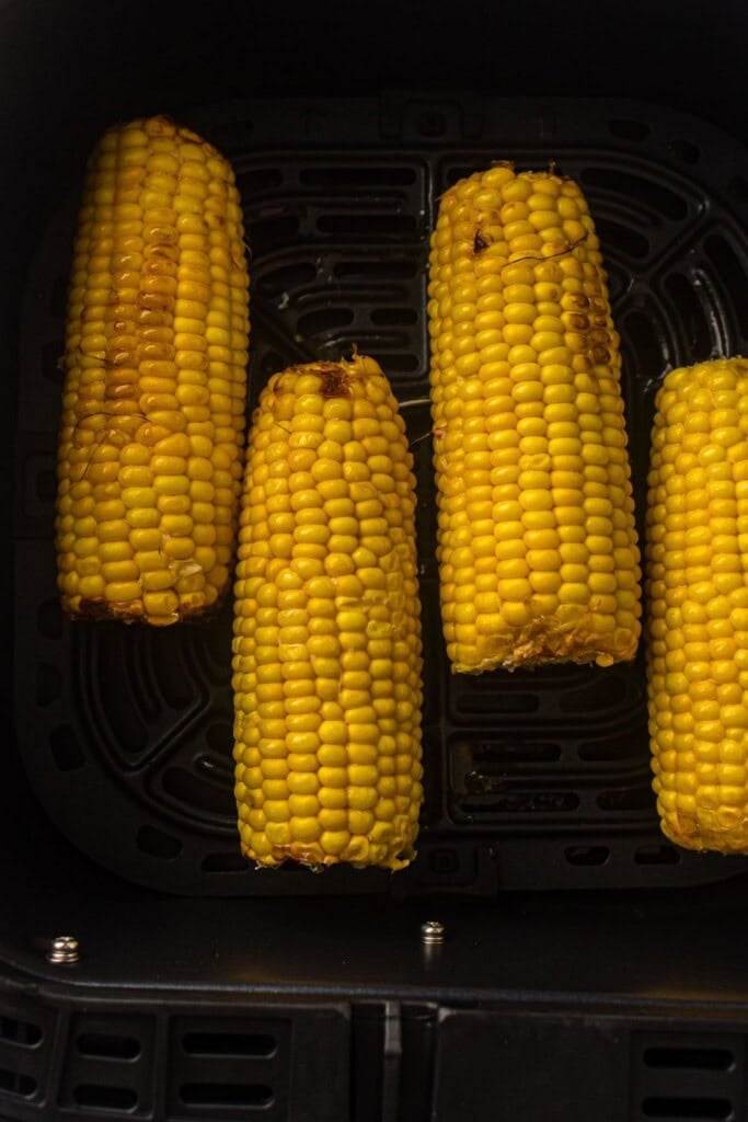 overhead view of charred corn in air fryer basket