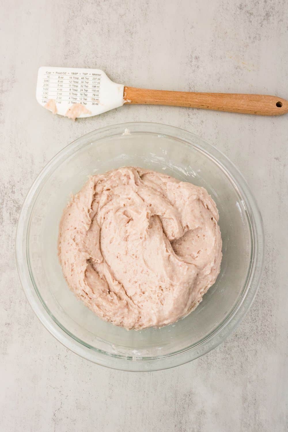 Pink gluten-free strawberry cake batter mixed in a glass bowl
