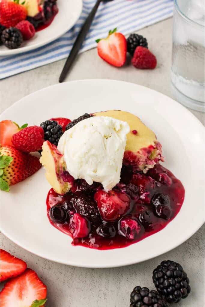 Vegan gluten free berry cobbler topped with a scoop of dairy free vanilla ice cream