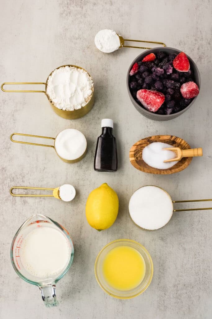 Ingredients for vegan gluten free berry cobbler arranged on a gray surface