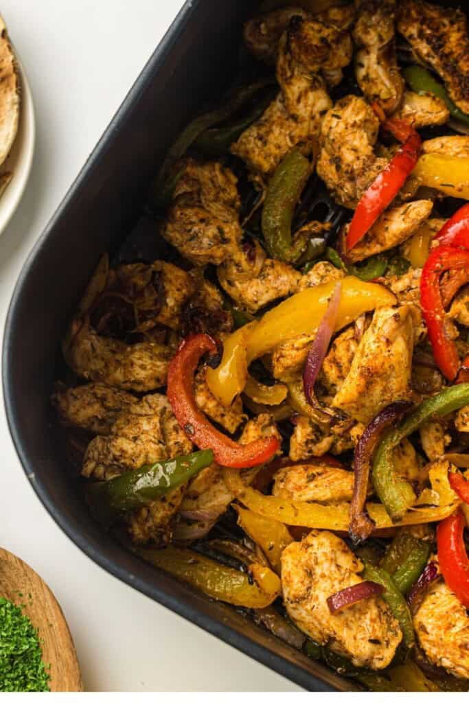 Air fryer chicken fajitas with peppers and onions in the air fryer basket