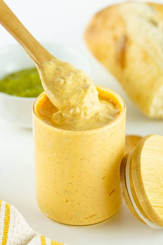 Spoon lifting creamy copycat Big Mac sauce from a glass jar