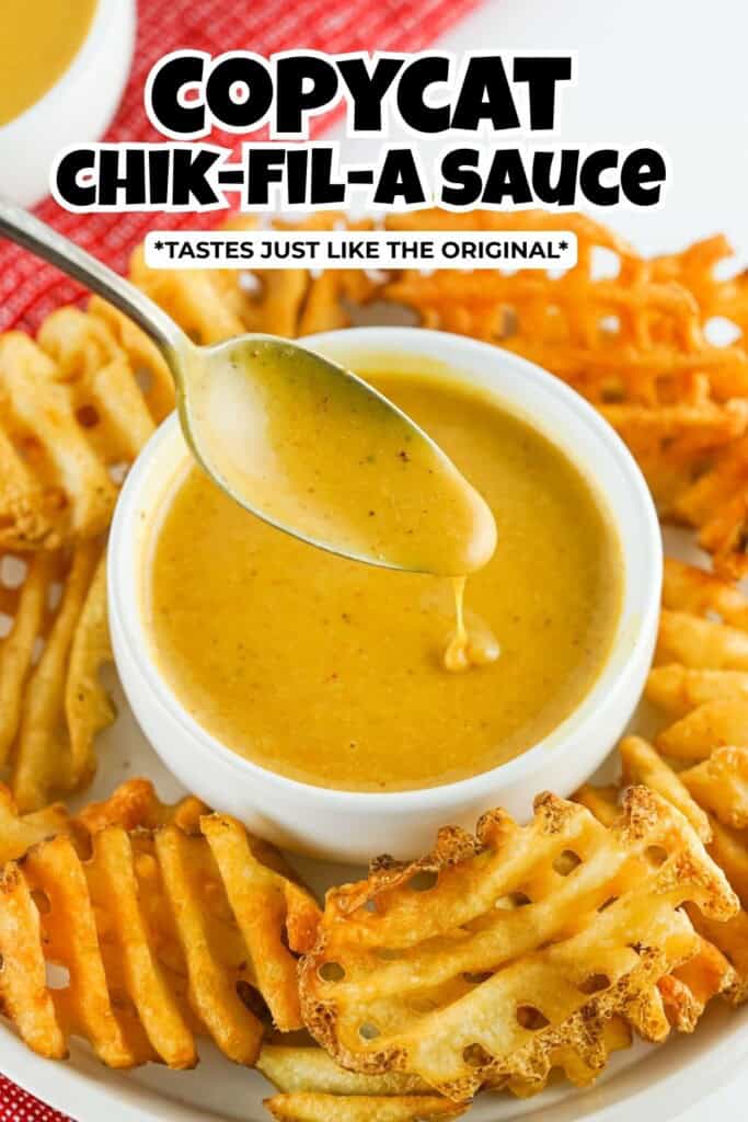 Copycat Chik-fil-A sauce in a white bowl with a spoon in it surrounded by waffle fries