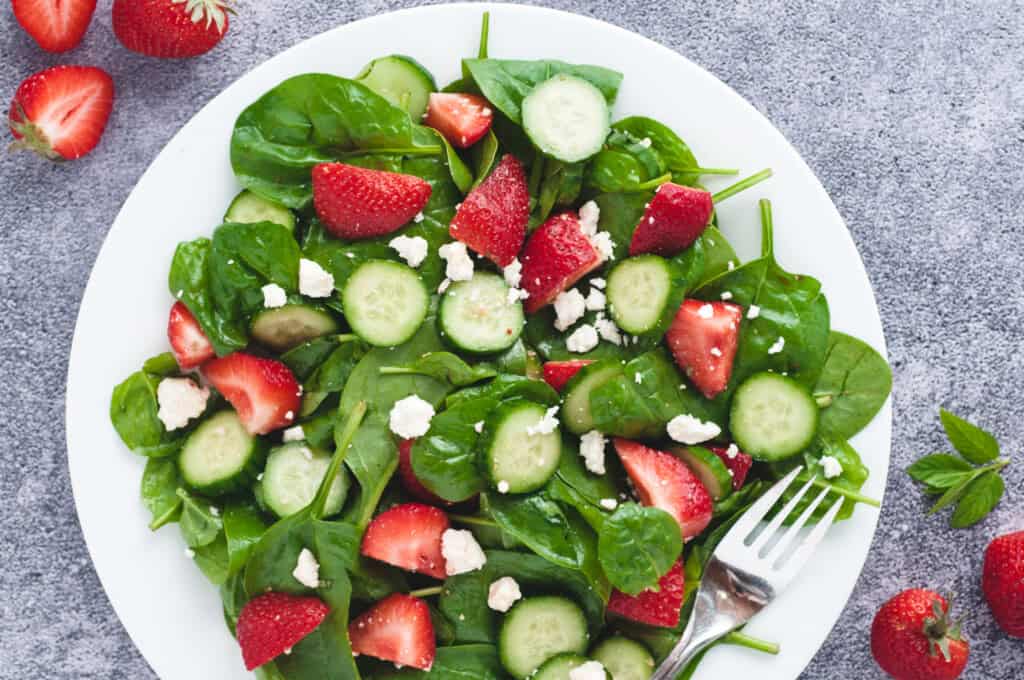 Cucumber salad with fresh strawberries, feta cheese and mint leaves.