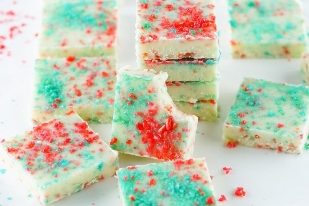 Firecracker fudge squares scattered on a white surface with loose Pop Rocks