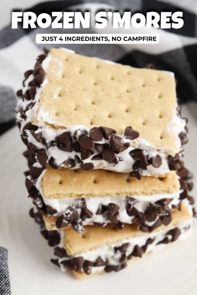 Frozen s'mores stacked on a white plate with mini chocolate chip edges and creamy marshmallow filling.