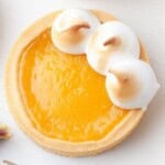 Mini lemon meringue tart with torched Italian meringue peaks and an edible pansy