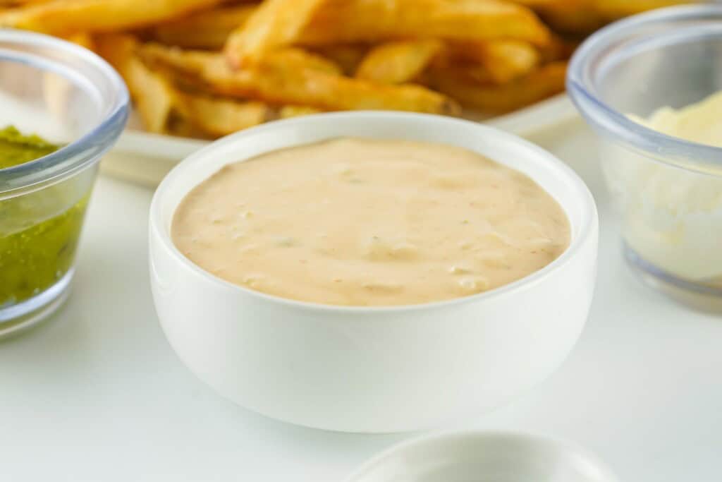 Hand dipping a french fry into copycat In-N-Out Animal Sauce
