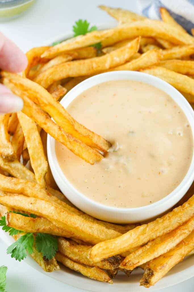French fry dipped into a bowl of homemade copycat Animal Sauce
