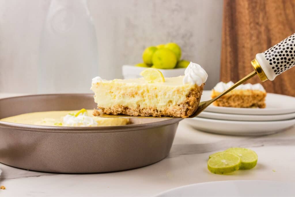 Side view of a classic key lime pie slice showing the creamy filling and graham cracker crust