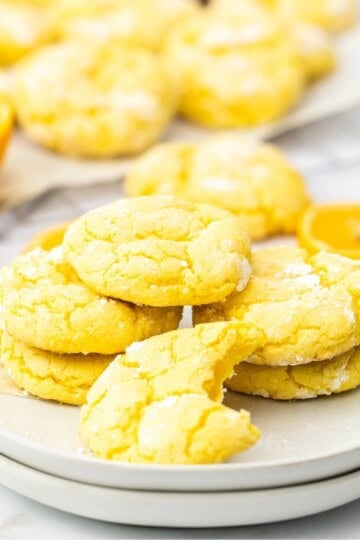 Lemon crinkle cookies with cake mix stacked on a white plate with a bottle of milk featured post