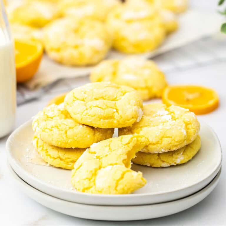 Lemon crinkle cookies with cake mix stacked on a white plate with a bottle of milk featured post