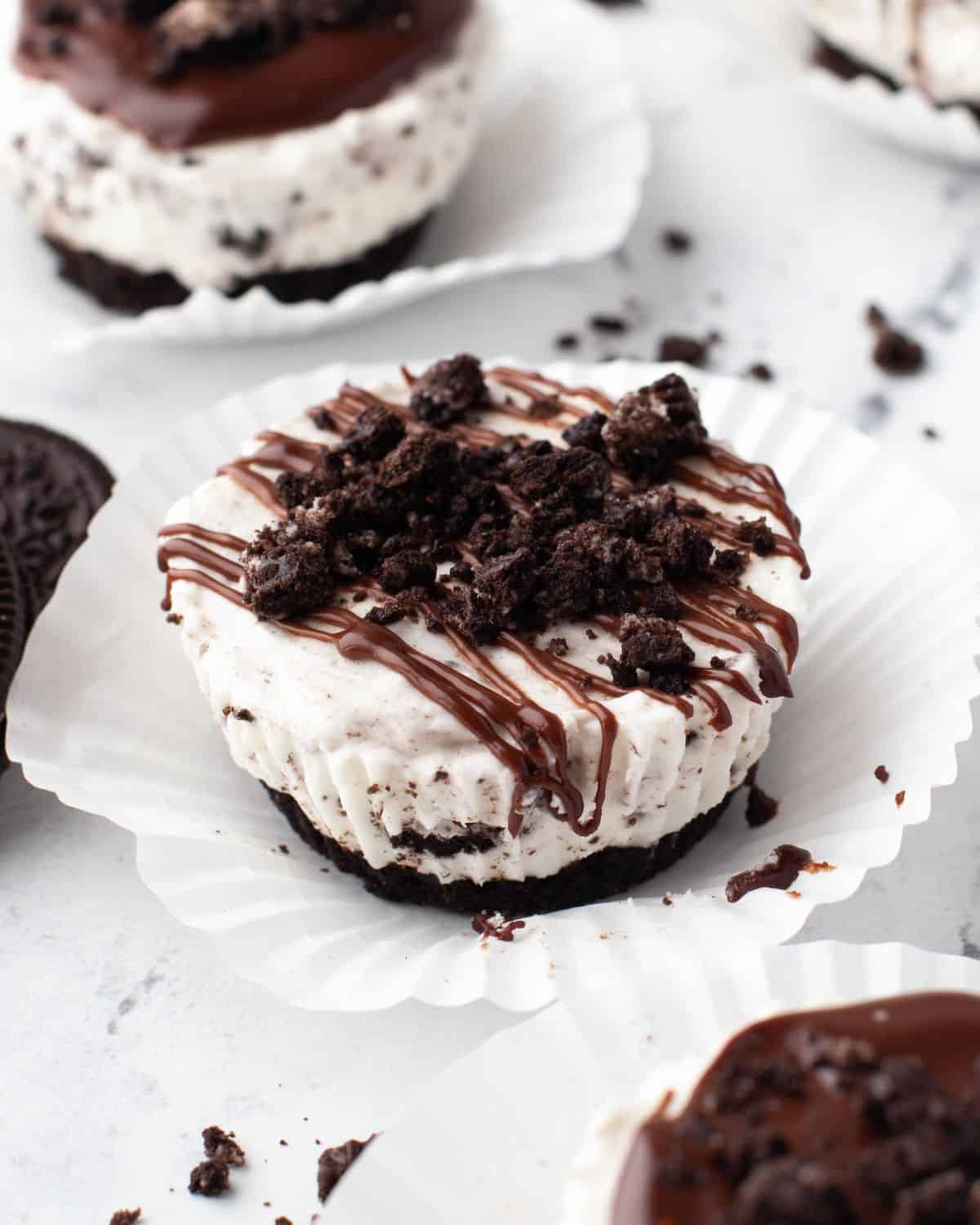 No bake mini Oreo cheesecake with chocolate ganache in a cupcake liner