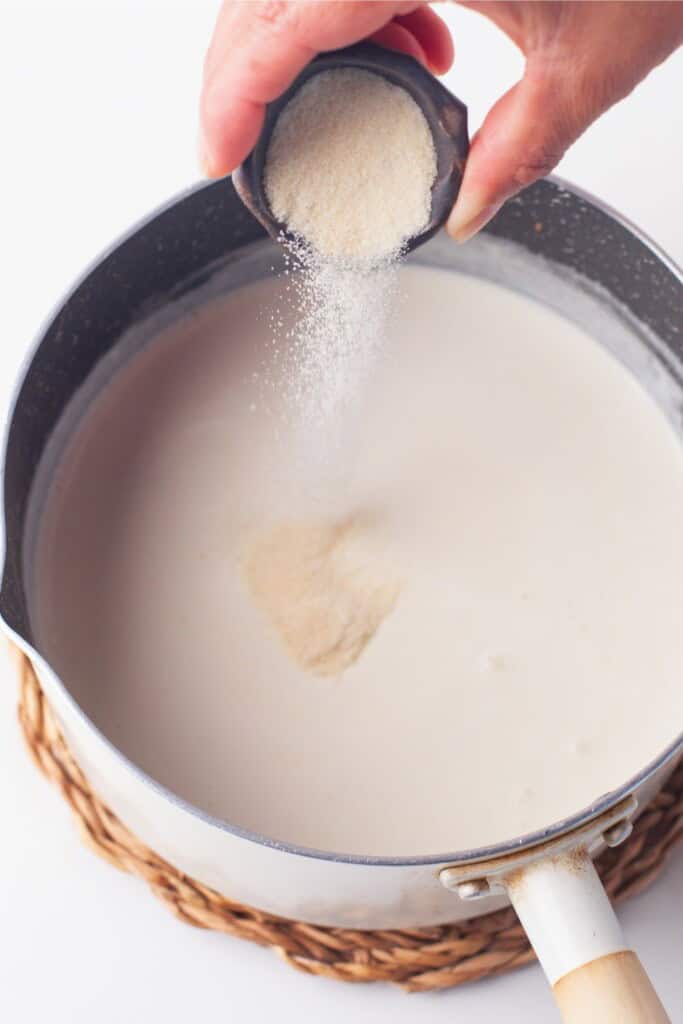 Sprinkling powdered gelatin over warm cream to bloom for panna cotta