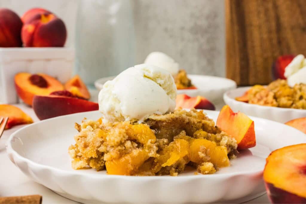 peach dump cake with vanilla ice cream and golden cake topping