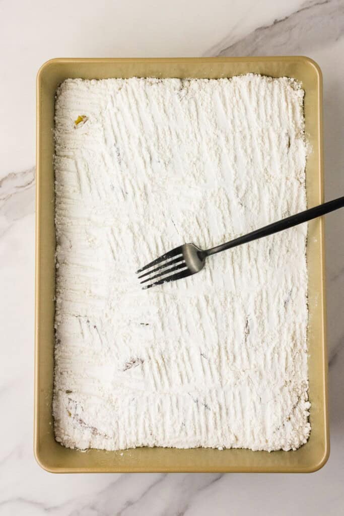 pressing dry cake mix into peaches with a fork