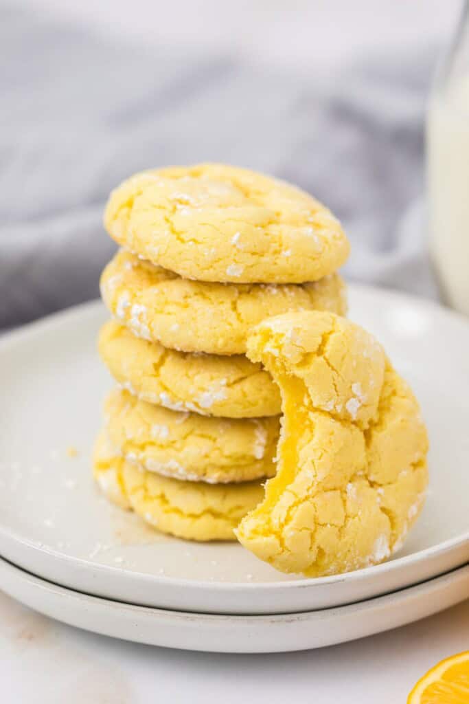 Stack of soft lemon cookies made with cake mix beside a bottle of milk
