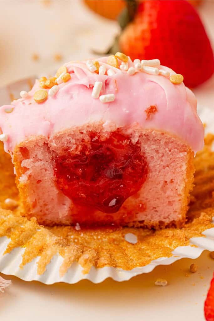 Close-up of glossy strawberry filling inside a pink champagne cupcake