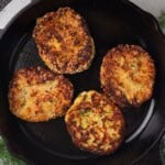 Zucchini patties with feta and tzatziki sauce in a skillet