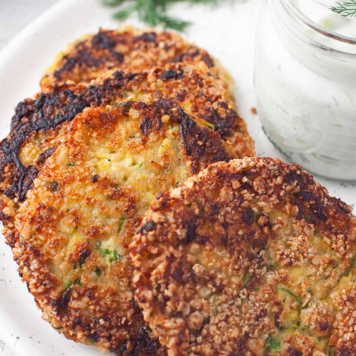 fried zucchini patties with tzatziki sauce featured image