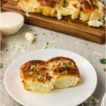 Cheesy Hawaiian roll garlic bread pulled apart with a long stretchy mozzarella cheese pull