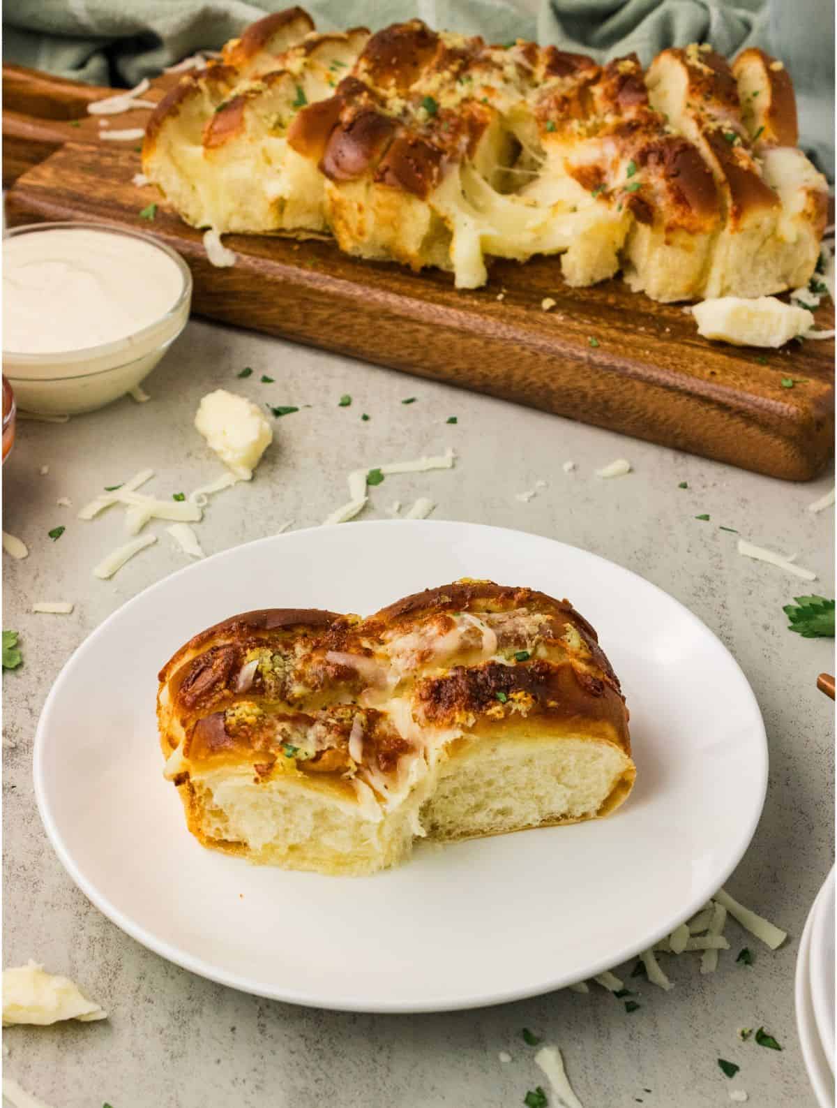 Cheesy Hawaiian roll garlic bread pulled apart with a long stretchy mozzarella cheese pull