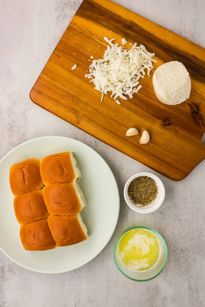 Ingredients for air fryer Hawaiian roll garlic bread including rolls, mozzarella, garlic, butter, and oregano