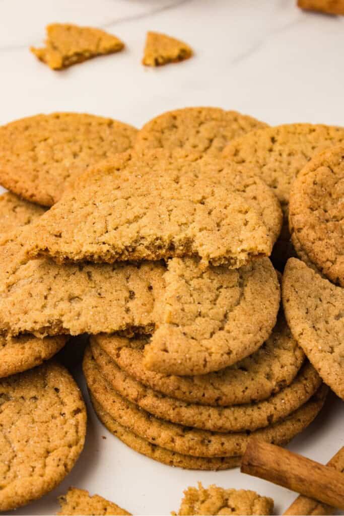 Brown butter apple cider snickerdoodle broken in half showing the soft chewy center