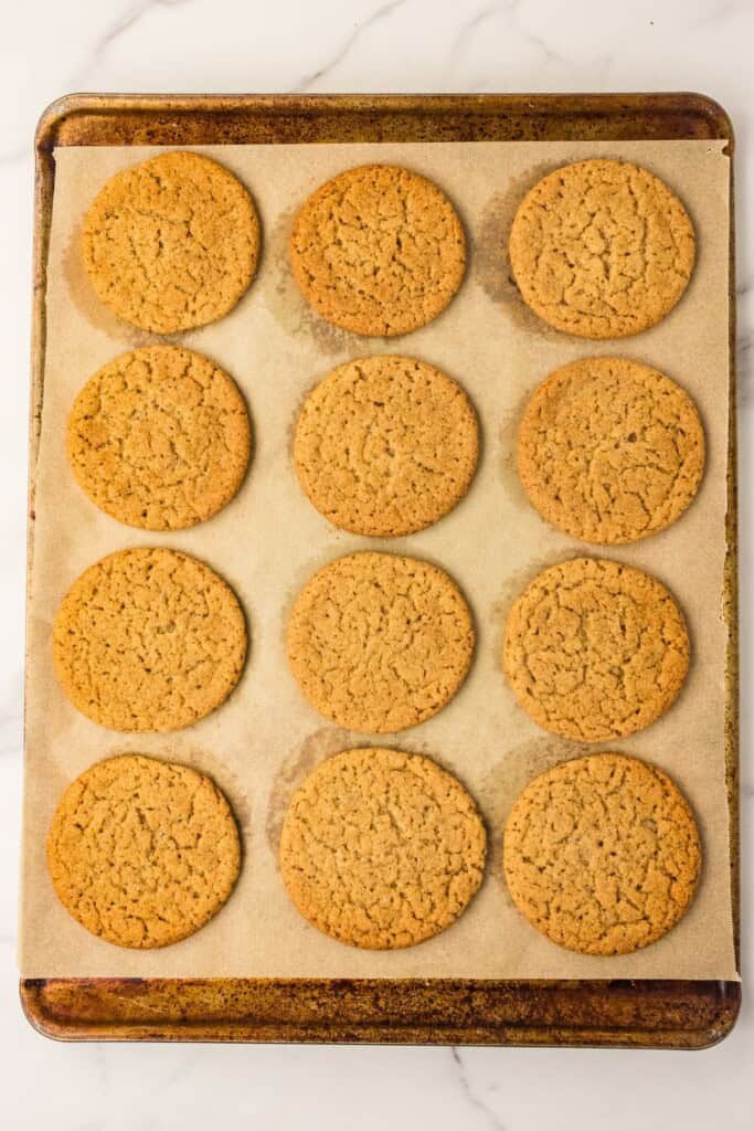 Baked brown butter apple cider snickerdoodles with puffed crackled tops on a sheet pan
